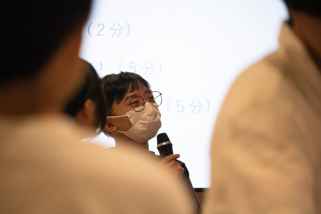写真。発表する少年。